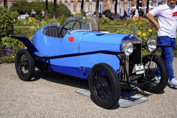 Oldtimer Classic, Gala International Concours d'Elegance Schwetzingen 2025, Germany, Europe, A blue classic car in retro style stands in the sunlight, surrounded by flowers