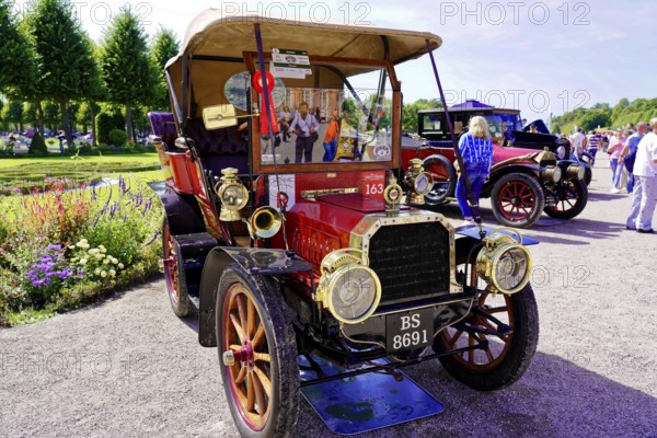 Oldtimer Classic, Gala International Concours d'Elegance Schwetzingen 2025, Germany, Europe, A red vintage car at a sunny event, surrounded by people and trees