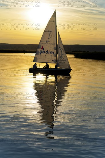 Lake Neusiedl, Burgenland, Austria, Europe, Sailboat in the sunset with calming water reflection and soft sky tones, Sailboats on Lake Neusiedl