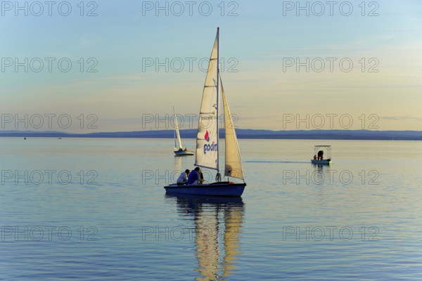 Lake Neusiedl, Burgenland, Austria, Europe, Sailboat at dusk on calm water with gentle waves, Sailboats on Lake Neusiedl