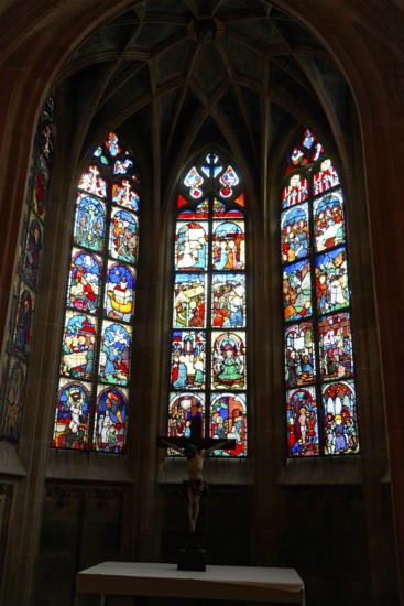 The interior of the largest Protestant church in Germany. It has the world's highest church tower, Ulm Minster, Germany, Europe, Gothic stained glass windows with a cross in the foreground in a church interior, Ulm