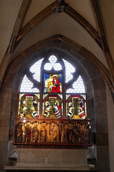 The interior of the largest Protestant church in Germany. It has the world's highest church tower, Ulm Minster, Germany, Europe, Colourful stained glass window with religious scenes in a Gothic setting, Ulm