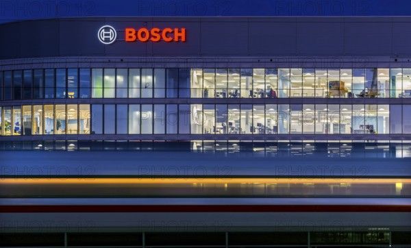 Modern office building of Bosch GmbH in Feuerbach at night with illuminated logo of the automotive supplier. Bosch Digital, Bosch IT Campus, Building 701, Stuttgart, Baden-Württemberg, Germany