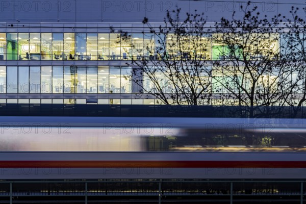 Office building at night. In front of it a passing ICE train of Deutsche Bahn AG. Stuttgart, Baden-Württemberg, Germany
