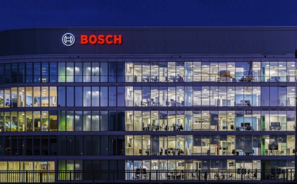 Modern office building of Bosch GmbH in Feuerbach at night with illuminated logo of the automotive supplier. Bosch Digital, Bosch IT Campus, Building 701, Stuttgart, Baden-Württemberg, Germany