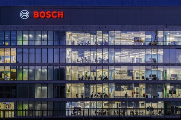 Modern office building of Bosch GmbH in Feuerbach at night with illuminated logo of the automotive supplier. Bosch Digital, Bosch IT Campus, Building 701, Stuttgart, Baden-Württemberg, Germany