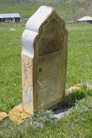 Old gravestone on a green meadow in a rural setting in sunny weather, old cemetery, Aghvorik, Shirak province, Armenia