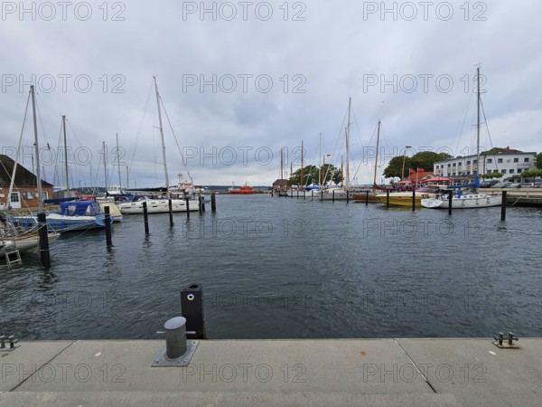 View of a harbour with several sailing boats and a cloudy sky in the background, Laboe, Kiel Fjord, Schleswig-Holstein, Germany