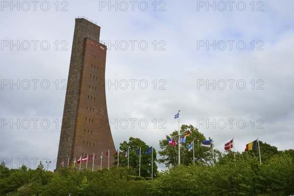Brick tower with flags surrounded by vegetation, naval memorial, Laboe, Kiel Fjord, Schleswig-Holstein, Germany
