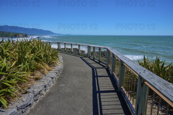 A walkway with railings offers a wide view over the sea and the coastline, Pancake Rocks, Westport, Greymouth, West Coast, South Island, New Zealand