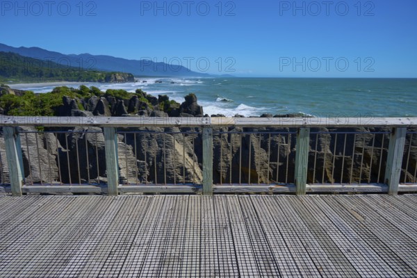 View from a platform with wooden railings of the rugged coastal rocks and the sea, Pancake Rocks, Westport, Greymouth, West Coast, South Island, New Zealand