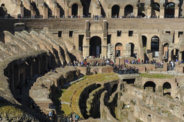 View of hypogeum from the time of Emperor Domitian exposed at the bottom front, in the centre of the picture behind it ancient west gate of Colosseum Amphitheatrum Flavium so-called Tor tor of Death Porta della Morte for the removal of killed gladiators, Rome, Latium, Italy