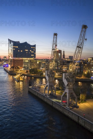 Aerial view of the Elbphilharmonie with Sandtorkai and historic cranes at the blue hour, Hamburg, Germany