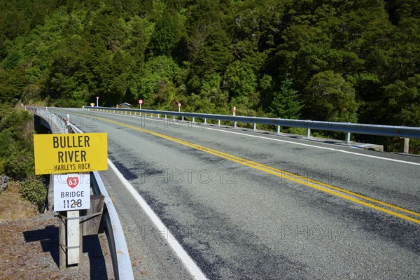 Road leads over bridge at Buller River, surrounded by forest and traffic signs, Buller River, Murchison, Tasman, South Island, New Zealand