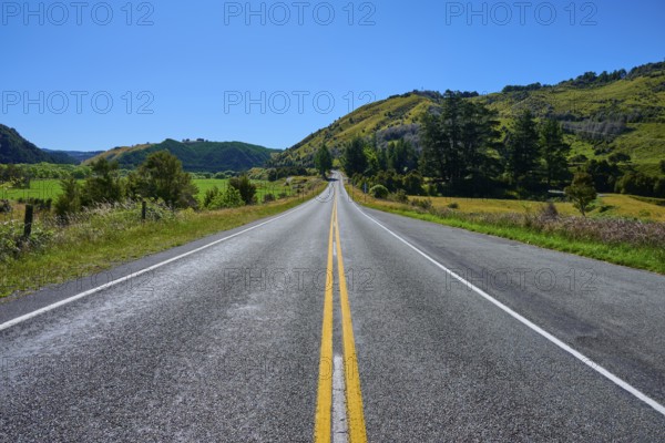 Straight country road with green hills and blue sky, peaceful natural scenery, Buller River, Murchison, Tasman, South Island, New Zealand