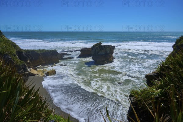 Breathtaking coastal landscape with rocks in the sea under a bright blue sky, Pancake Rocks, Westport, Greymouth, West Coast, South Island, New Zealand