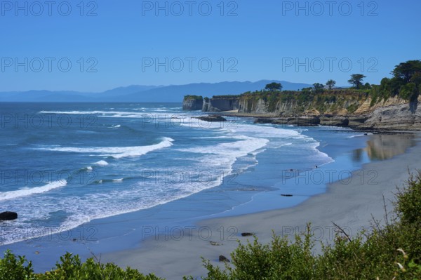 Wide view of the coast with waves, cliffs and blue sky, Cape Foulwind, West Coast, South Island, New Zealand
