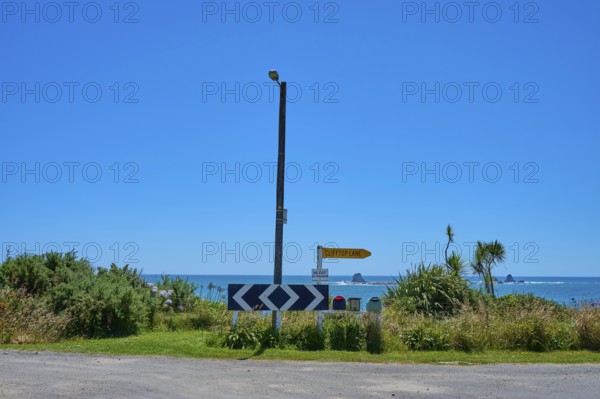View of a coastline with road signs and blue sky, Cape Foulwind, West Coast, South Island, New Zealand