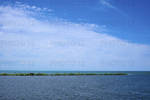 Sweeping view of the calm sea under a partly cloudy blue sky, Mana Bay, Patea, Taranaki, North Island, New Zealand