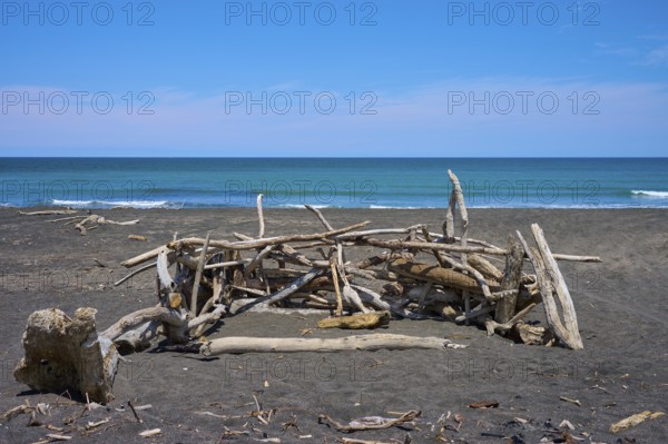 Driftwood beach hut by the ocean, Mana Bay, Patea, Taranaki, North Island, New Zealand