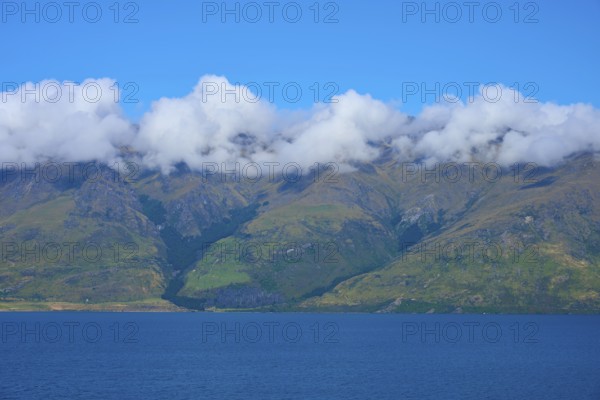Mountains with a wreath of clouds over a blue lake under a clear sky, Drift Bay, Lake Wakatipu, Queenstown-Lakes District, Otago, South Island, New Zealand