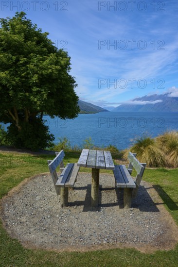 Single picnic table overlooking lake and mountains in scenic setting, Drift Bay, Lake Wakatipu, Queenstown-Lakes District, Otago, South Island, New Zealand