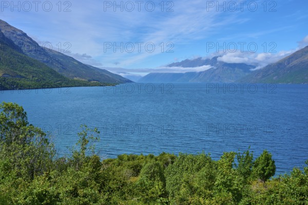 View of a lake framed by mountains and a blue sky, Drift Bay, Lake Wakatipu, Queenstown-Lakes District, Otago, South Island, New Zealand