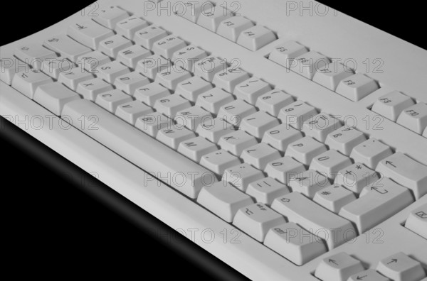 Studio photography of a grey key pad in black reflective back