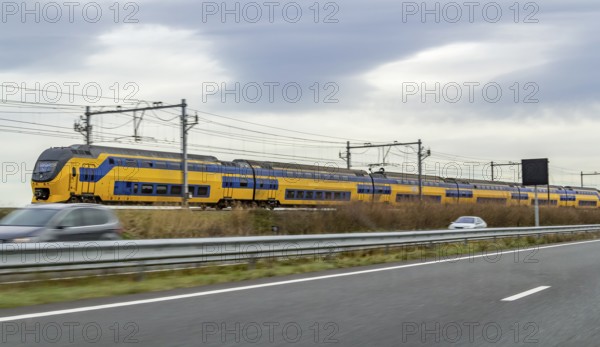 Train near a highway seen in the Netherlands