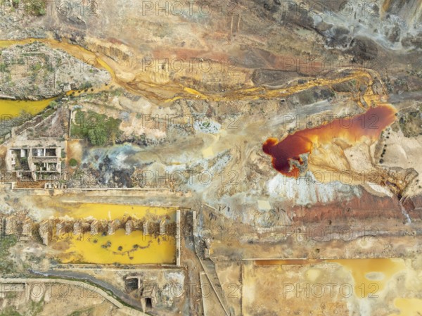 Old mining site and deep orange-red hues in the water of a pool in the mineral-rich area of the Rio Tinto mines. The colour is caused by oxidised iron minerals. Aerial view. Drone shot. Huelva province, Andalusia, Spain