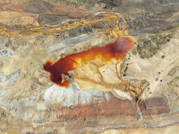 Old mining site and deep orange-red hues in the water of a pool in the mineral-rich area of the Rio Tinto mines. The colour is caused by oxidised iron minerals. Aerial view. Drone shot. Huelva province, Andalusia, Spain