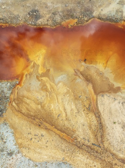 Deep orange-red hues in the water of a pool in the mineral-rich area of the Rio Tinto mines. The colour is caused by oxidised iron minerals. Aerial view. Drone shot. Huelva province, Andalusia, Spain