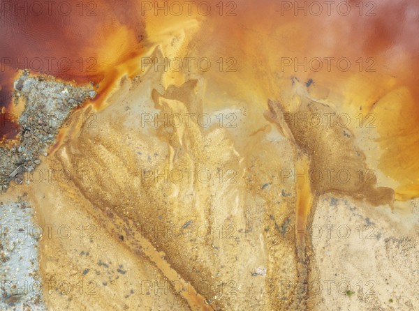 Abstract patterns in a pool in the mineral-rich area of the Rio Tinto mines. The colour is caused by oxidised iron minerals. Aerial view. Drone shot. Huelva province, Andalusia, Spain