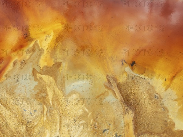 Abstract patterns in a pool in the mineral-rich area of the Rio Tinto mines. The colour is caused by oxidised iron minerals. Aerial view. Drone shot. Huelva province, Andalusia, Spain