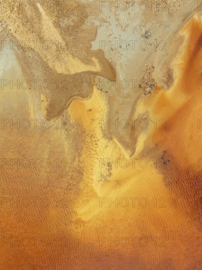 Abstract patterns in a pool in the mineral-rich area of the Rio Tinto mines. The colour is caused by oxidised iron minerals. Aerial view. Drone shot. Huelva province, Andalusia, Spain