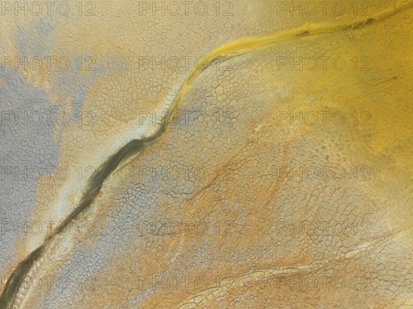 Abstract patterns in a waste pond in the mineral-rich area of the Rio Tinto mines. The colour is caused by oxidised iron minerals. Aerial view. Drone shot. Huelva province, Andalusia, Spain
