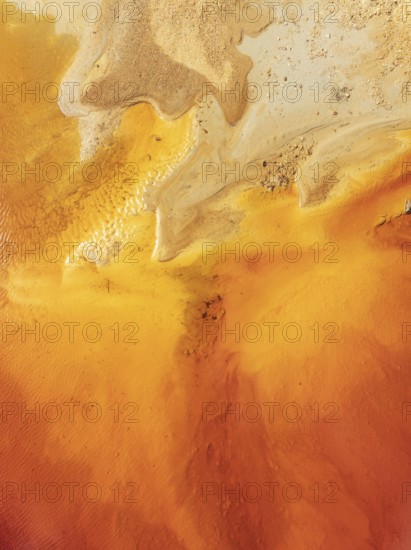 Abstract patterns in a pool in the mineral-rich area of the Rio Tinto mines. The colour is caused by oxidised iron minerals. Aerial view. Drone shot. Huelva province, Andalusia, Spain