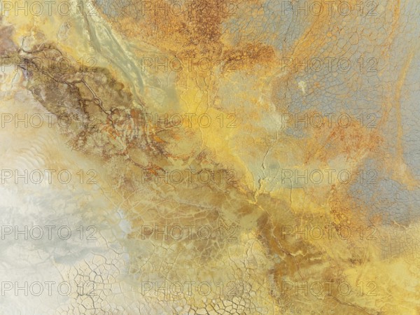 Abstract patterns in a waste pond in the mineral-rich area of the Rio Tinto mines. The colour is caused by oxidised iron minerals. Aerial view. Drone shot. Huelva province, Andalusia, Spain