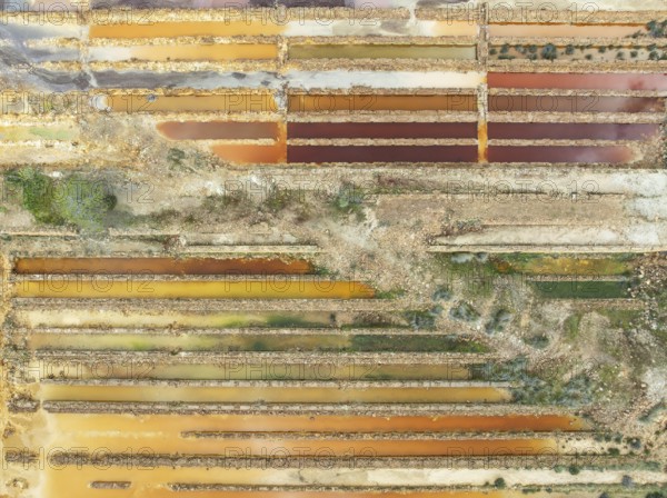 Abandoned saline ponds in the mineral-rich area of the Rio Tinto mines, hence the different colours caused by oxidised iron minerals. Aerial view. Drone shot. Huelva province, Andalusia, Spain