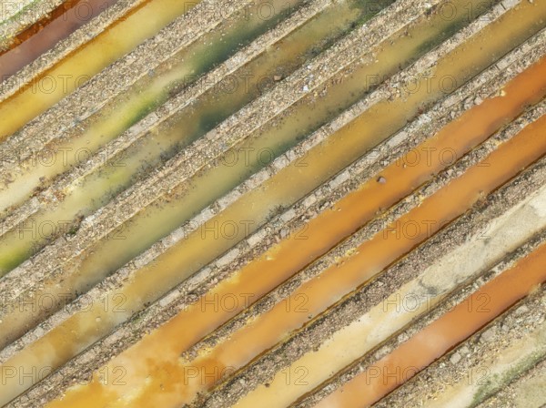 Abandoned saline ponds in the mineral-rich area of the Rio Tinto mines, hence the different colours caused by oxidised iron minerals. Aerial view. Drone shot. Huelva province, Andalusia, Spain