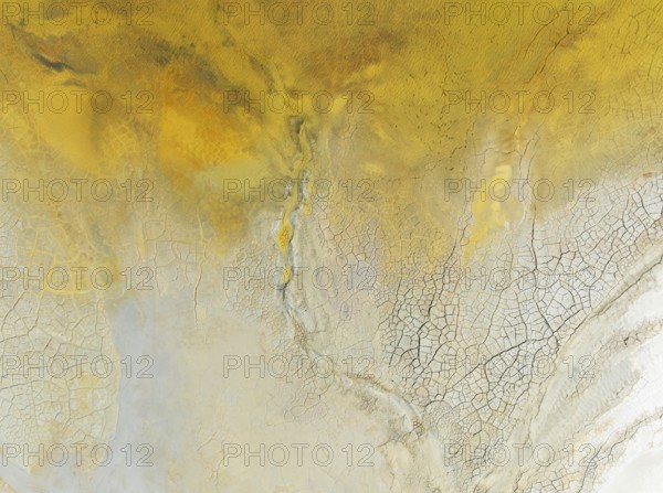 Abstract patterns in a waste pond in the mineral-rich area of the Rio Tinto mines. The colour is caused by oxidised iron minerals. Aerial view. Drone shot. Huelva province, Andalusia, Spain
