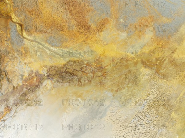 Abstract patterns in a waste pond in the mineral-rich area of the Rio Tinto mines. The colour is caused by oxidised iron minerals. Aerial view. Drone shot. Huelva province, Andalusia, Spain