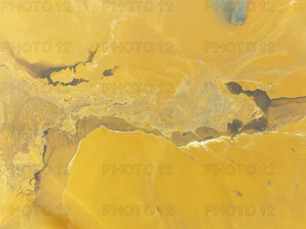 Abstract patterns in a waste pond in the mineral-rich area of the Rio Tinto mines. The colour is caused by oxidised iron minerals. Aerial view. Drone shot. Huelva province, Andalusia, Spain