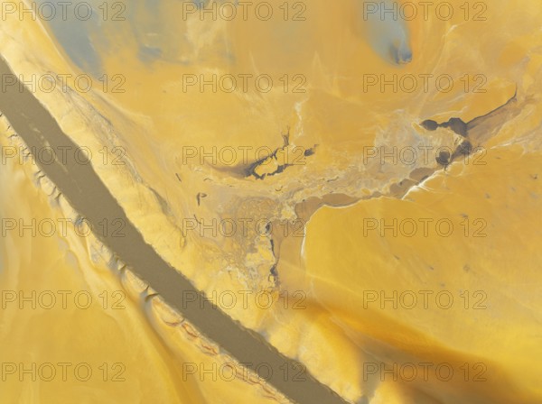 Abstract patterns in a waste pond in the mineral-rich area of the Rio Tinto mines. The colour is caused by oxidised iron minerals. Aerial view. Drone shot. Huelva province, Andalusia, Spain