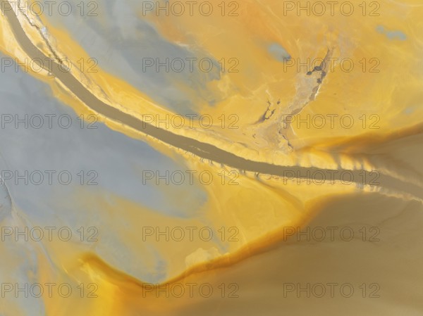 Abstract patterns in a waste pond in the mineral-rich area of the Rio Tinto mines. The colour is caused by oxidised iron minerals. Aerial view. Drone shot. Huelva province, Andalusia, Spain