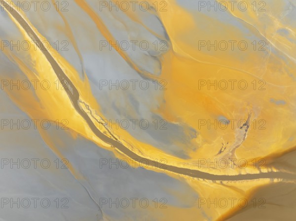 Abstract patterns in a waste pond in the mineral-rich area of the Rio Tinto mines. The colour is caused by oxidised iron minerals. Aerial view. Drone shot. Huelva province, Andalusia, Spain