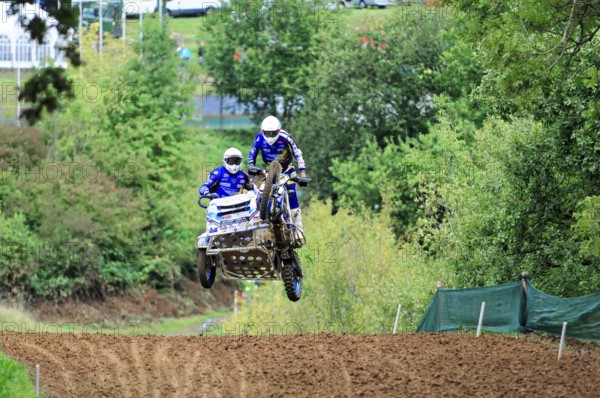 Motocross, Rudersberg, Baden-Württemberg, Germany, Europe, Two riders jump through the air over a track with their sidecar motorbike, Rudersberg Motocross