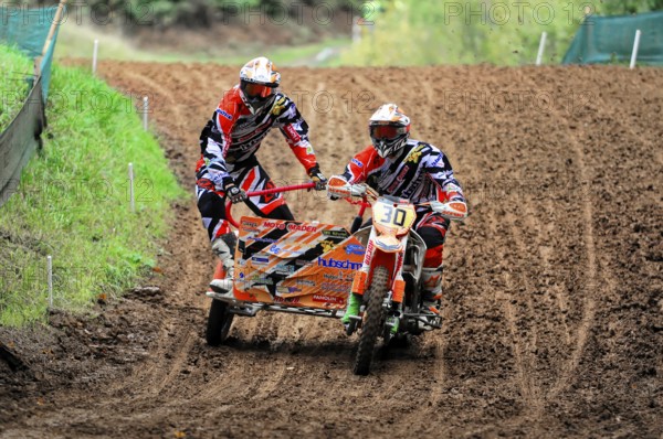 Motocross, Rudersberg, Baden-Württemberg, Germany, Europe, Sidecar motorbike riders ride through a muddy bend at high speed in a competition, Rudersberg motocross