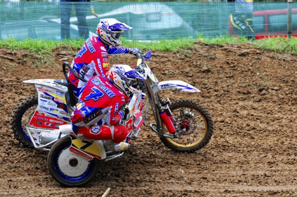 Motocross, Rudersberg, Baden-Württemberg, Germany, Europe, Two riders lean on a sidecar motorbike during the race on muddy ground, Rudersberg motocross