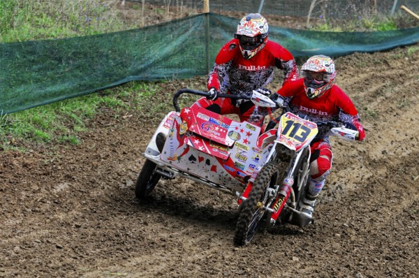 Motocross, Rudersberg, Baden-Württemberg, Germany, Europe, Rider duo in full speed through muddy race track, both in red gear, Rudersberg motocross